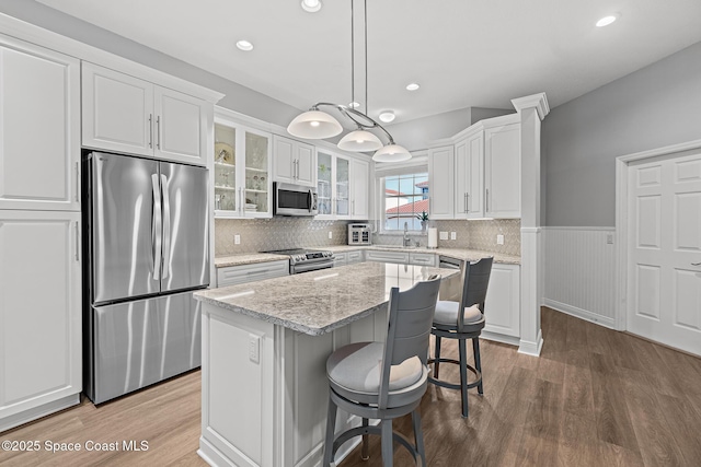 kitchen with white cabinetry, pendant lighting, stainless steel appliances, and a center island