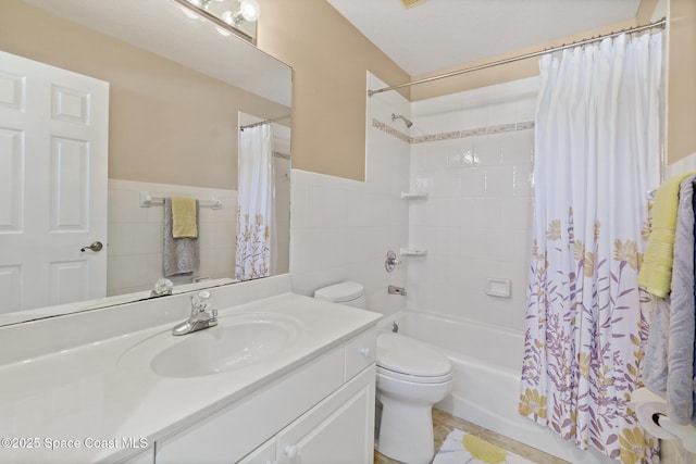 full bathroom featuring vanity, toilet, shower / bath combo with shower curtain, and tile walls