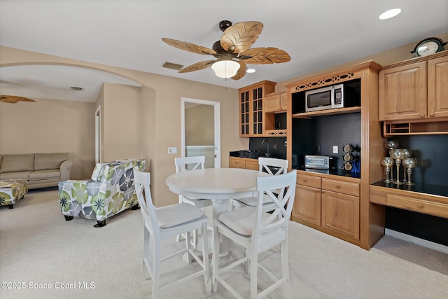 carpeted dining space featuring built in desk and ceiling fan