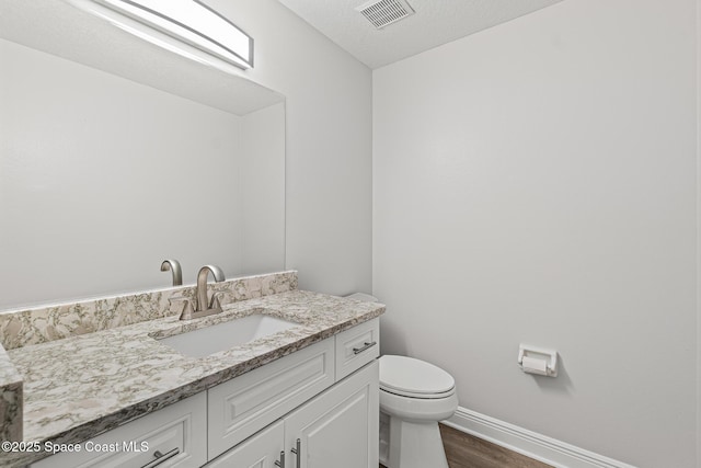 bathroom with hardwood / wood-style flooring, vanity, and toilet