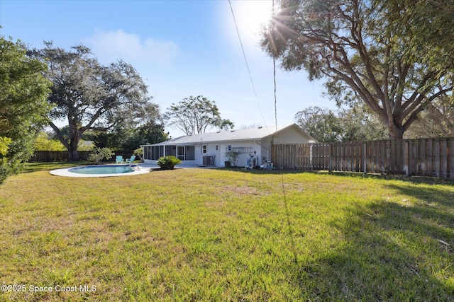 view of yard featuring cooling unit, a fenced in pool, and a sunroom