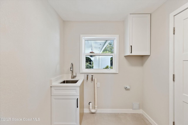 clothes washing area with cabinets, light tile patterned flooring, sink, and hookup for an electric dryer