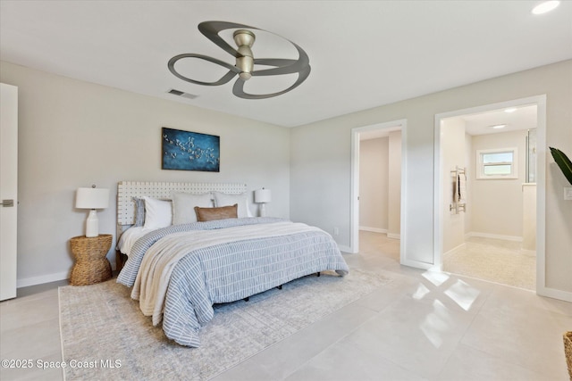 bedroom featuring light tile patterned flooring, ceiling fan, and ensuite bath