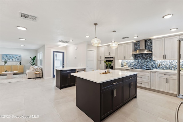 kitchen featuring wall chimney range hood, black electric stovetop, white cabinets, a kitchen island, and decorative light fixtures