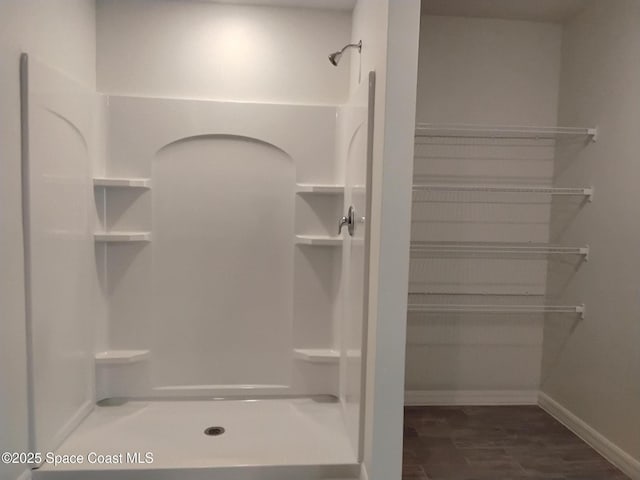 bathroom with hardwood / wood-style floors and a shower