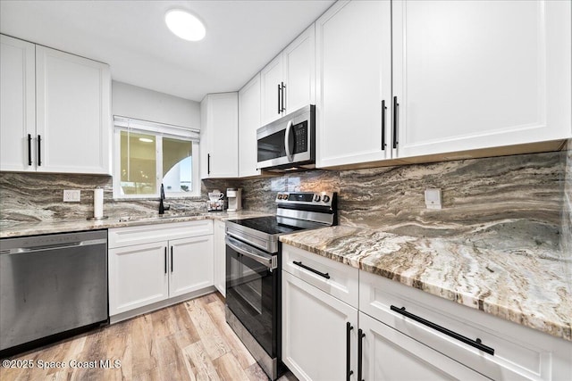 kitchen featuring white cabinetry, appliances with stainless steel finishes, and light hardwood / wood-style floors