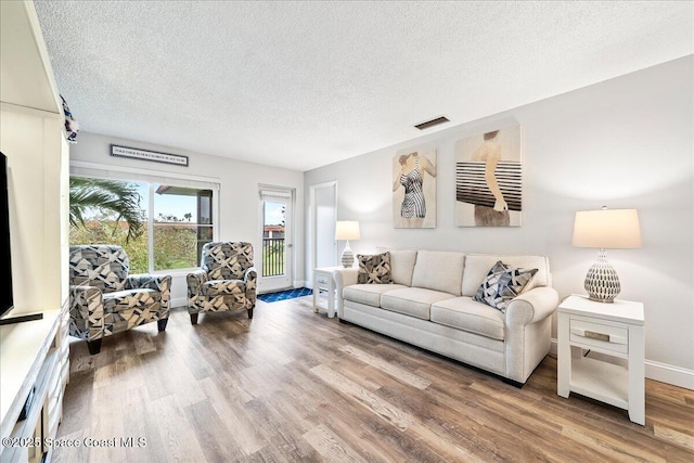 living room with hardwood / wood-style flooring and a textured ceiling