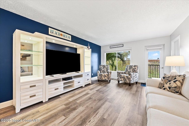 living room featuring wood-type flooring and a textured ceiling