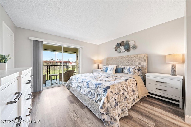 bedroom with wood-type flooring, access to outside, and a textured ceiling