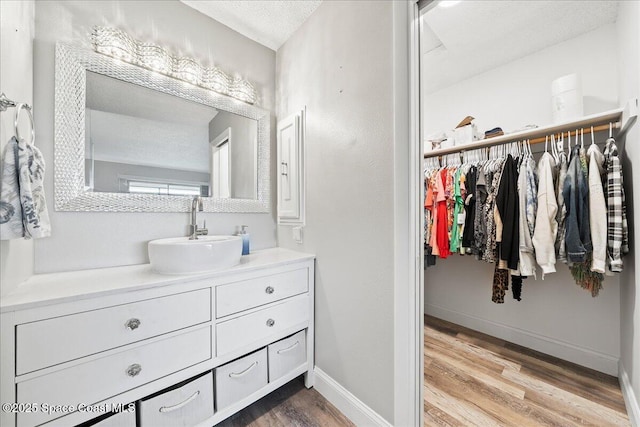 bathroom featuring vanity, wood-type flooring, and a textured ceiling