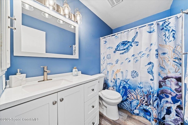 bathroom with a shower with curtain, vanity, toilet, and hardwood / wood-style floors