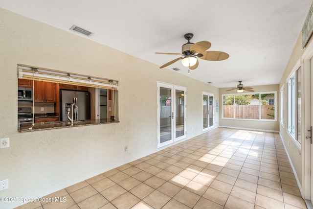 unfurnished sunroom featuring sink and ceiling fan