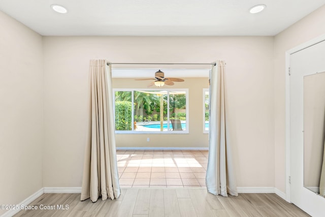 unfurnished room with ceiling fan and light hardwood / wood-style flooring