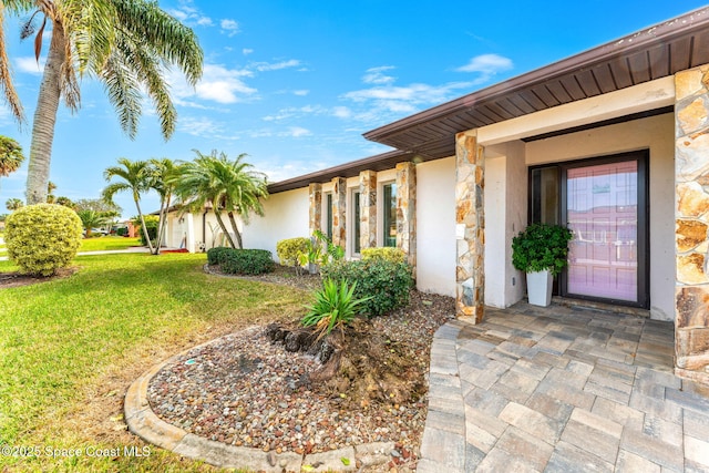 property entrance featuring a lawn