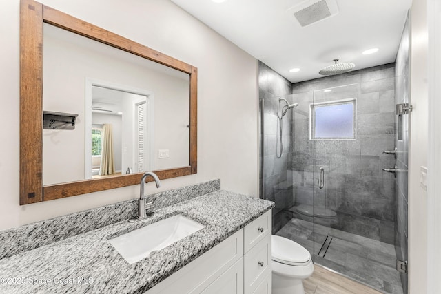 bathroom with vanity, toilet, a shower with door, and hardwood / wood-style floors