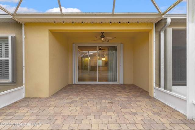 entrance to property featuring ceiling fan and a patio