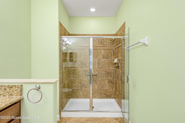 bathroom with vanity, an enclosed shower, tile patterned flooring, and a textured ceiling