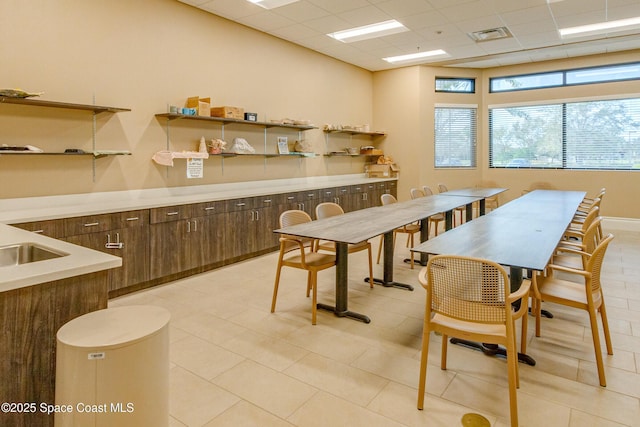 tiled dining space featuring a paneled ceiling