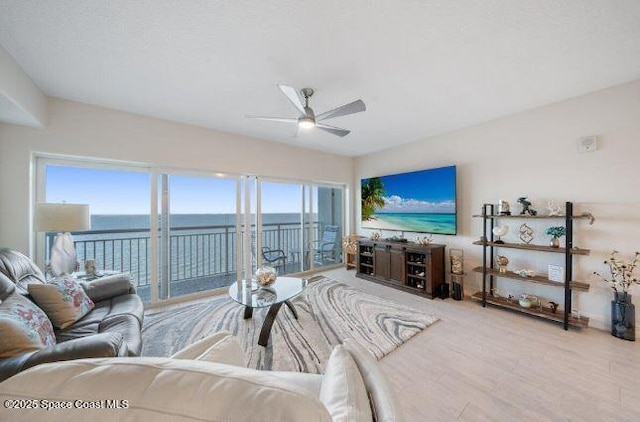 living room with ceiling fan, a healthy amount of sunlight, and light hardwood / wood-style flooring