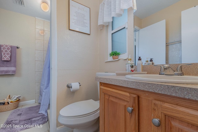 bathroom featuring vanity, tile patterned floors, and toilet