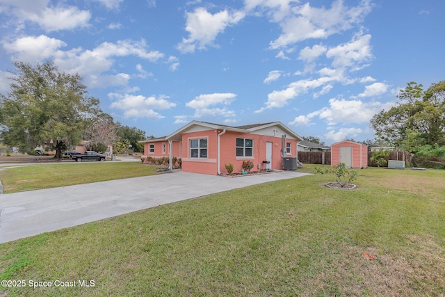 view of front of home featuring a front yard, central AC unit, and a storage shed