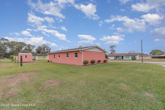 view of side of home featuring a storage shed and a yard