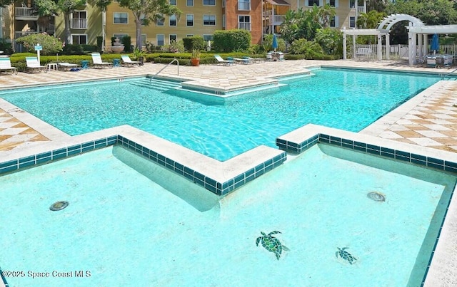 view of pool with a hot tub, a pergola, and a patio