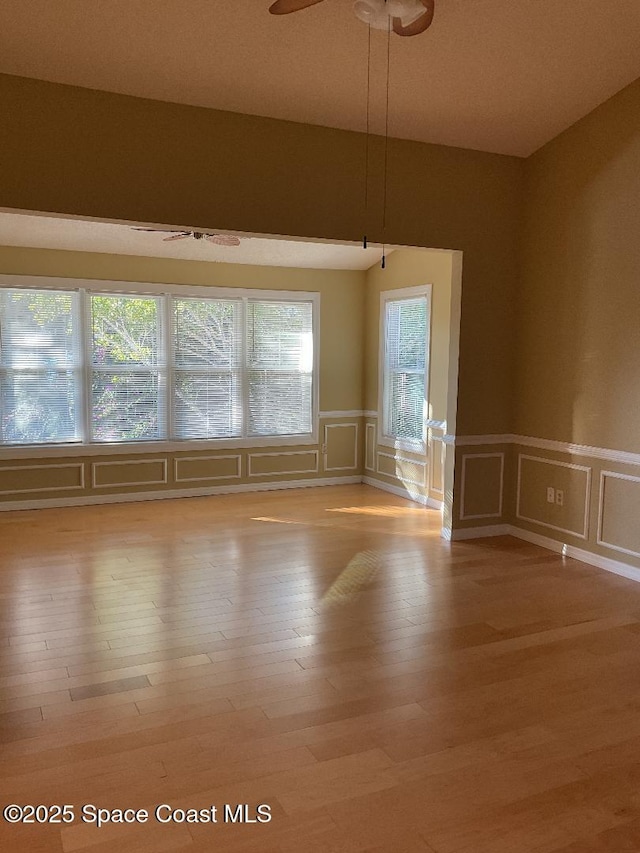 empty room with ceiling fan and light wood-type flooring