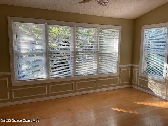 unfurnished sunroom featuring lofted ceiling, a healthy amount of sunlight, and ceiling fan