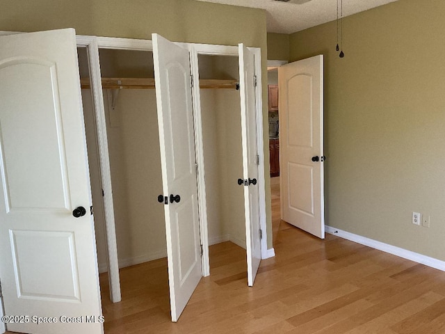 unfurnished bedroom with a textured ceiling and light wood-type flooring