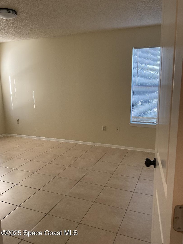 tiled spare room with a textured ceiling