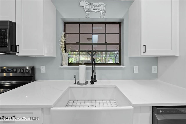 kitchen with electric range, dishwasher, sink, and white cabinets