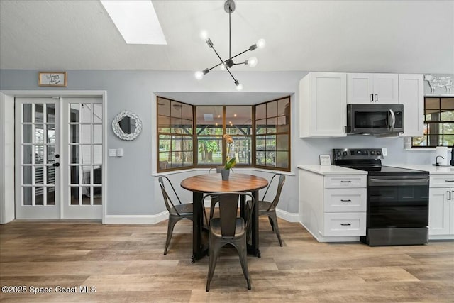 kitchen featuring decorative light fixtures, white cabinetry, light hardwood / wood-style floors, stainless steel appliances, and an inviting chandelier