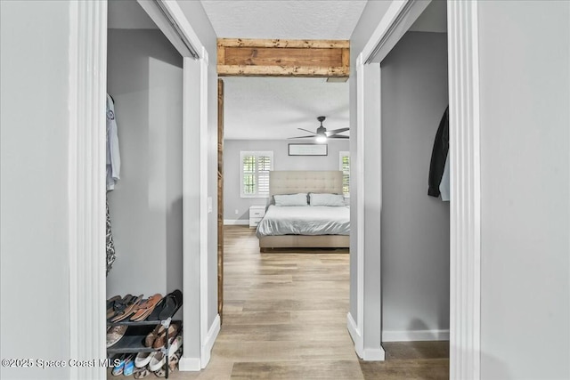 hallway featuring wood-type flooring and a textured ceiling