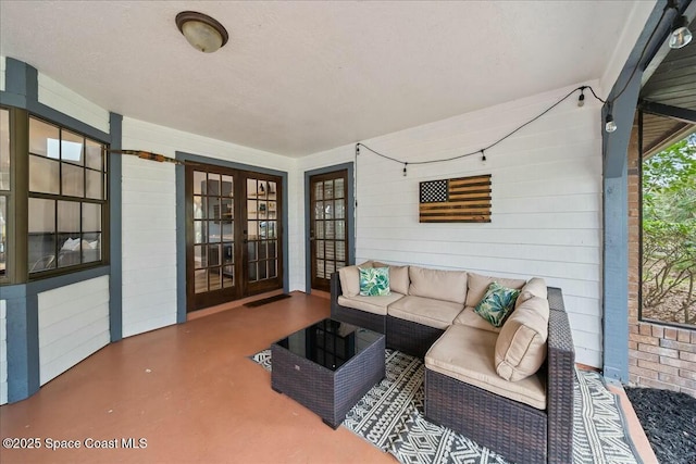 interior space featuring concrete floors, wooden walls, and french doors