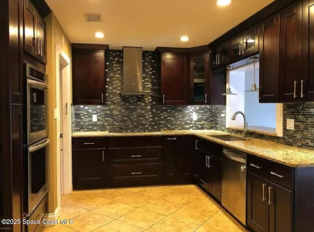 kitchen featuring wall chimney exhaust hood, appliances with stainless steel finishes, light tile patterned flooring, and tasteful backsplash