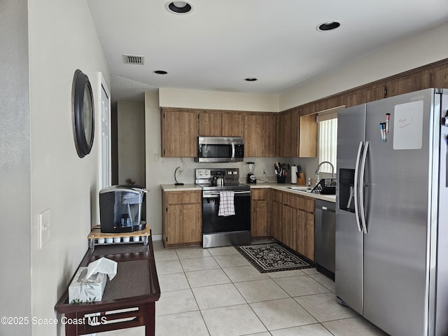 813 Pine Shadows Ave, Rockledge, FL 32955 - kitchen with visible vents, appliances with stainless steel finishes, a sink, light tile patterned floors, and light countertops