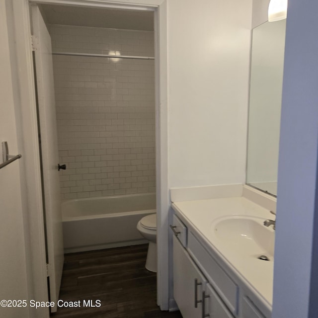 full bathroom with vanity, tiled shower / bath, wood-type flooring, and toilet