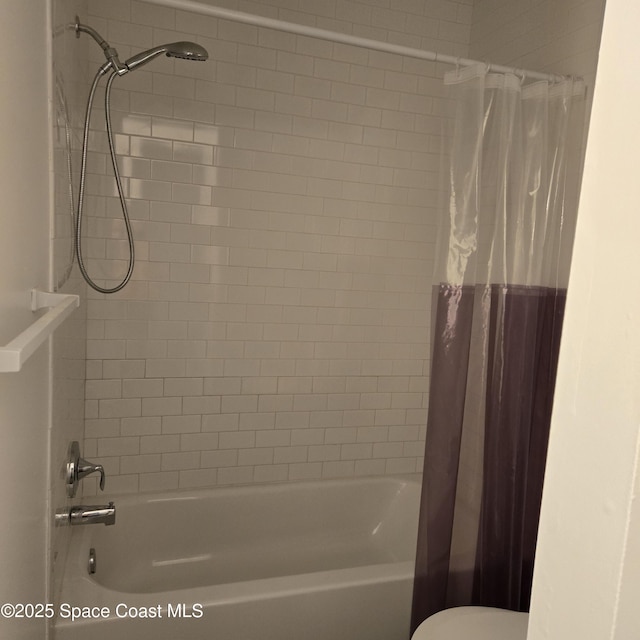 bathroom featuring shower / bath combination with curtain and toilet