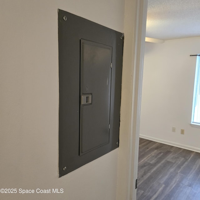 details with electric panel, hardwood / wood-style floors, and a textured ceiling