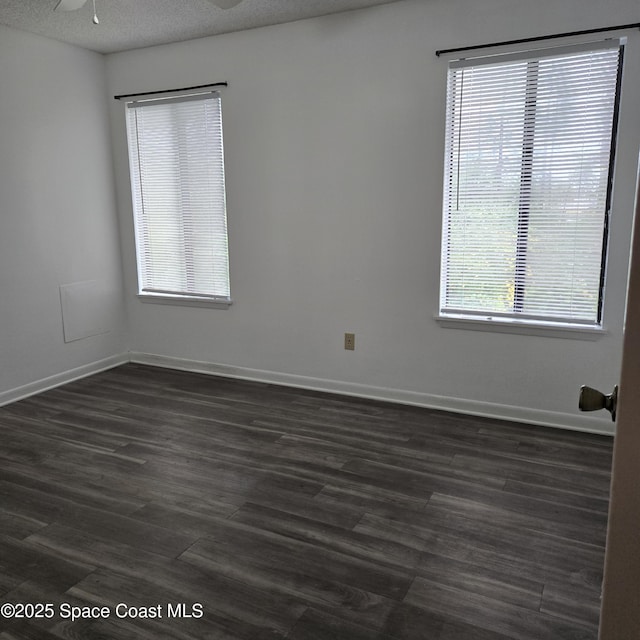 spare room with a textured ceiling, dark hardwood / wood-style floors, and ceiling fan