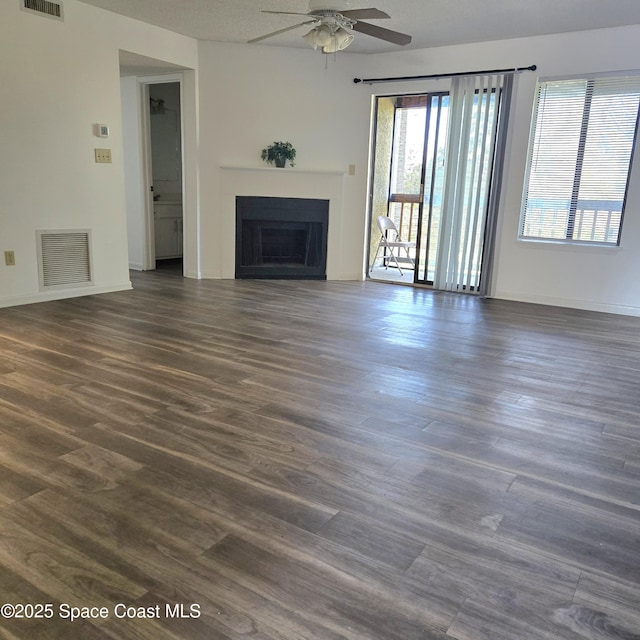 unfurnished living room with ceiling fan and dark hardwood / wood-style flooring