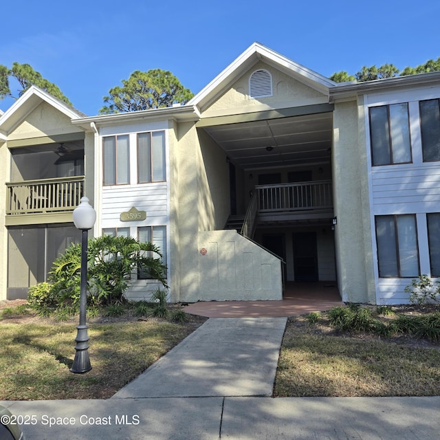 view of front of property with ceiling fan and a balcony