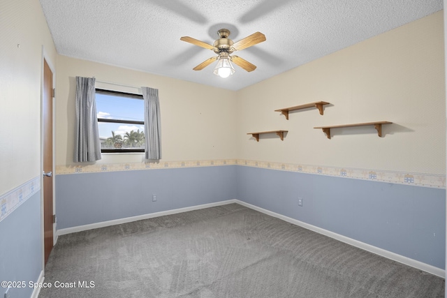 spare room featuring ceiling fan, carpet floors, and a textured ceiling