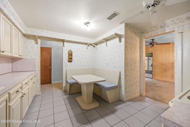 interior space featuring light tile patterned flooring, ceiling fan, and cream cabinets