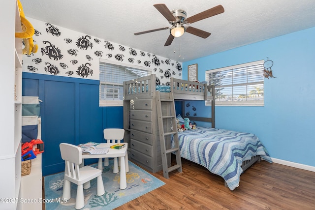 bedroom featuring ceiling fan, hardwood / wood-style floors, and a textured ceiling