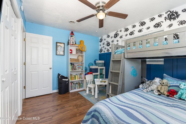 bedroom with dark hardwood / wood-style floors, a textured ceiling, ceiling fan, and a closet