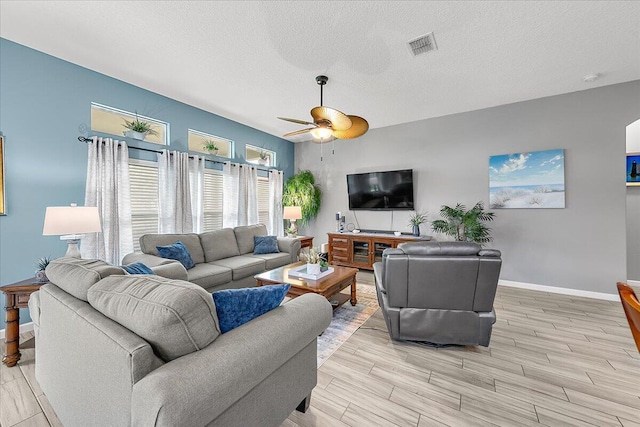 living room featuring a textured ceiling and ceiling fan