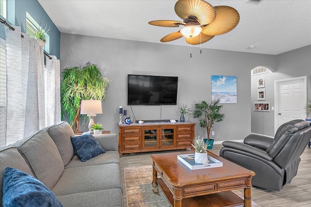 living room featuring ceiling fan and a textured ceiling