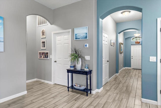 entrance foyer with a textured ceiling and light hardwood / wood-style flooring